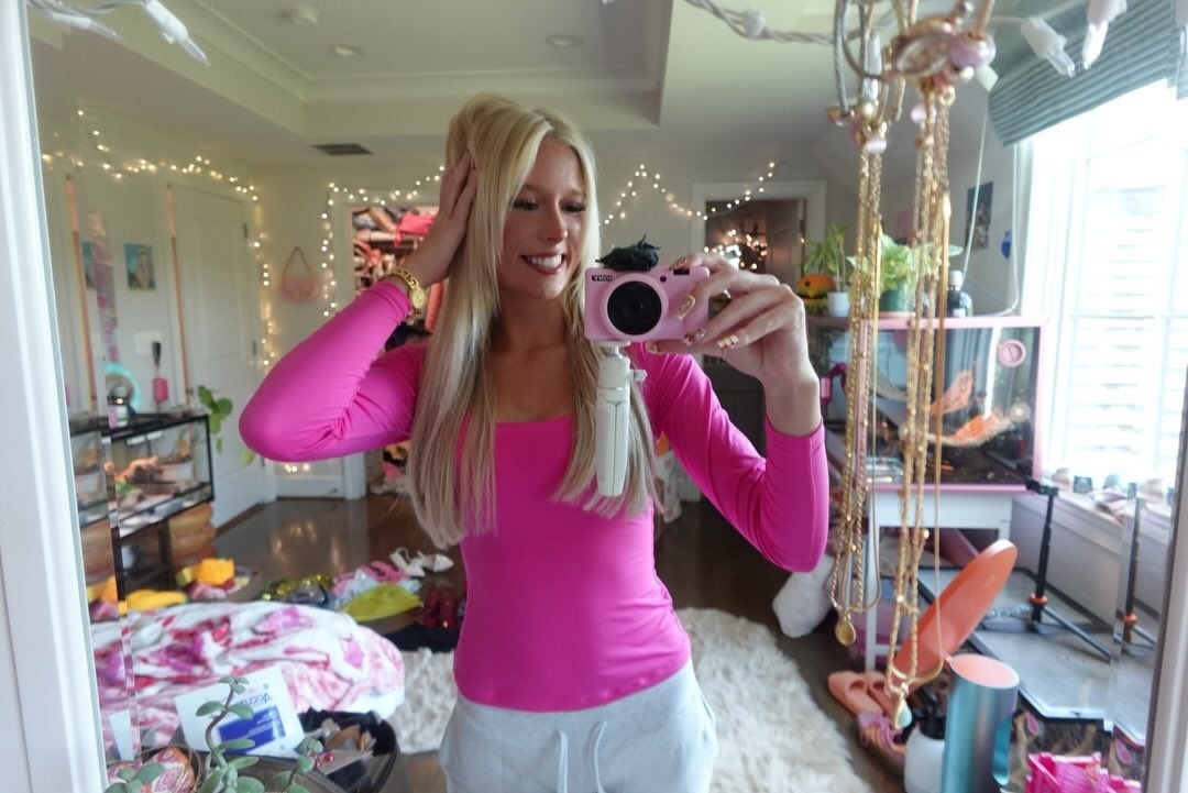 Samara in a bright pink top taking a mirror photo